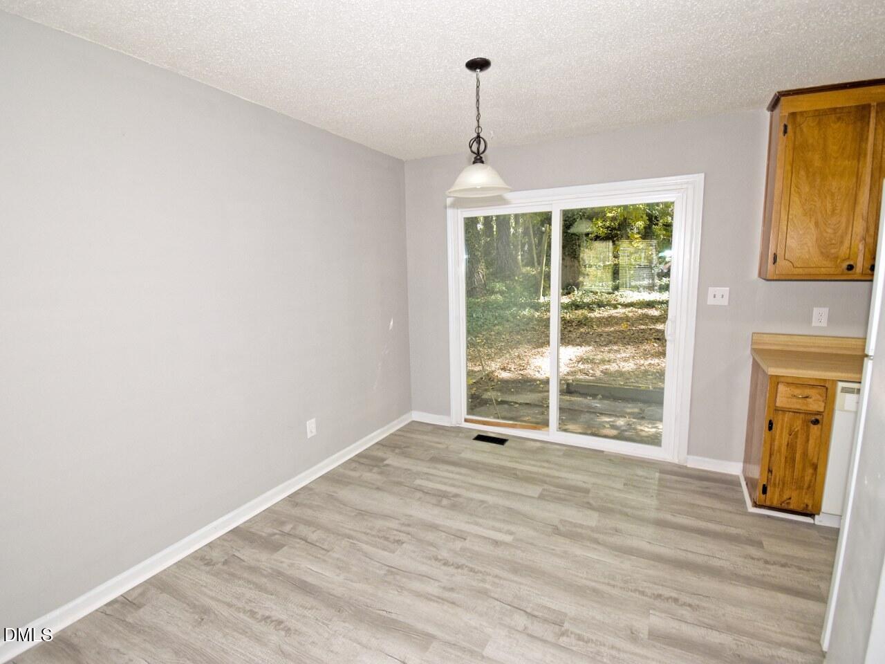 841 Barringer Drive, Unit A Raleigh, NC 27606 - Photo 6 of 23 a view of wooden floor cabinets and a window in an empty room