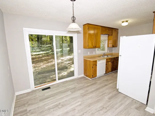 a view of a kitchen with a sink and wooden floor