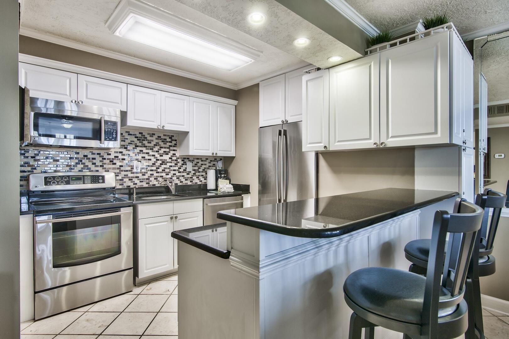 500 Gulf Shore Drive, Unit 119B Destin, FL 32541 - Photo 11 of 35 a kitchen with stainless steel appliances granite countertop a stove a sink and a refrigerator