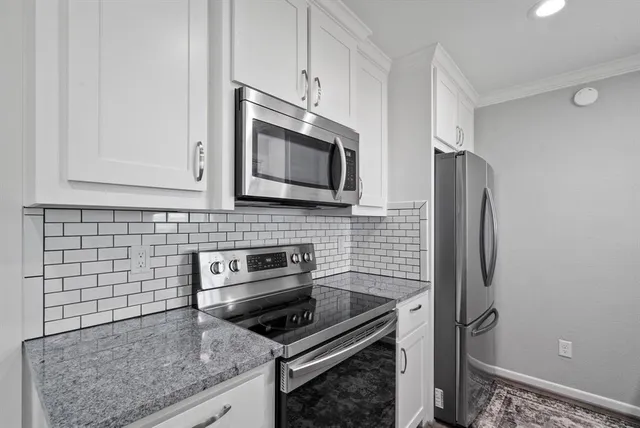 a kitchen with stainless steel appliances granite countertop a stove microwave and refrigerator