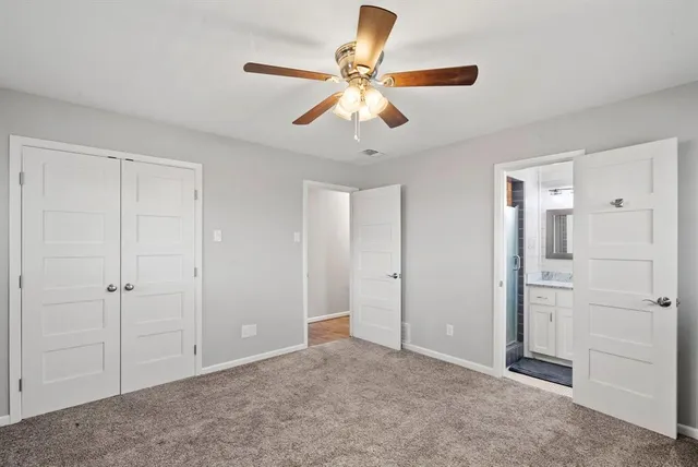 a view of an empty room and chandelier fan