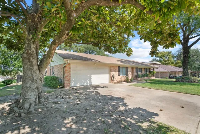 a front view of a house with a yard and trees