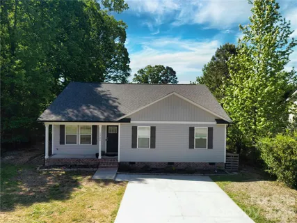 an aerial view of a house with a yard and trees