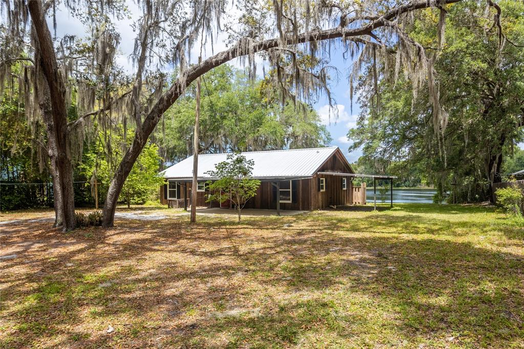 a front view of a house with a yard and trees