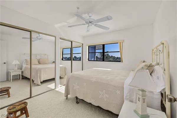 a bedroom with a bed mirror and window