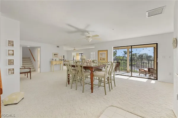 a dining room with furniture and a floor to ceiling window