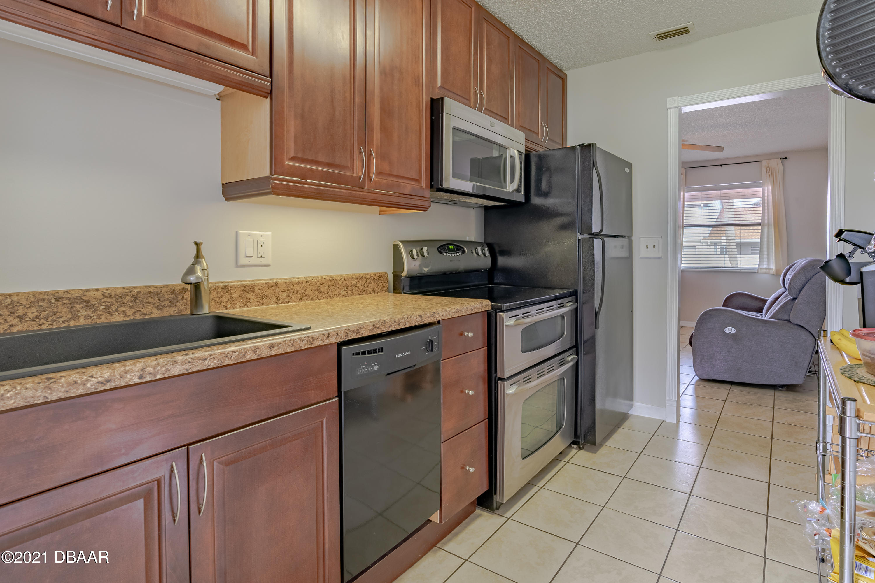 202 Northshore Drive, Unit B Ormond Beach, FL 32176 - Photo 11 of 25 a kitchen with stainless steel appliances granite countertop a sink stove and refrigerator