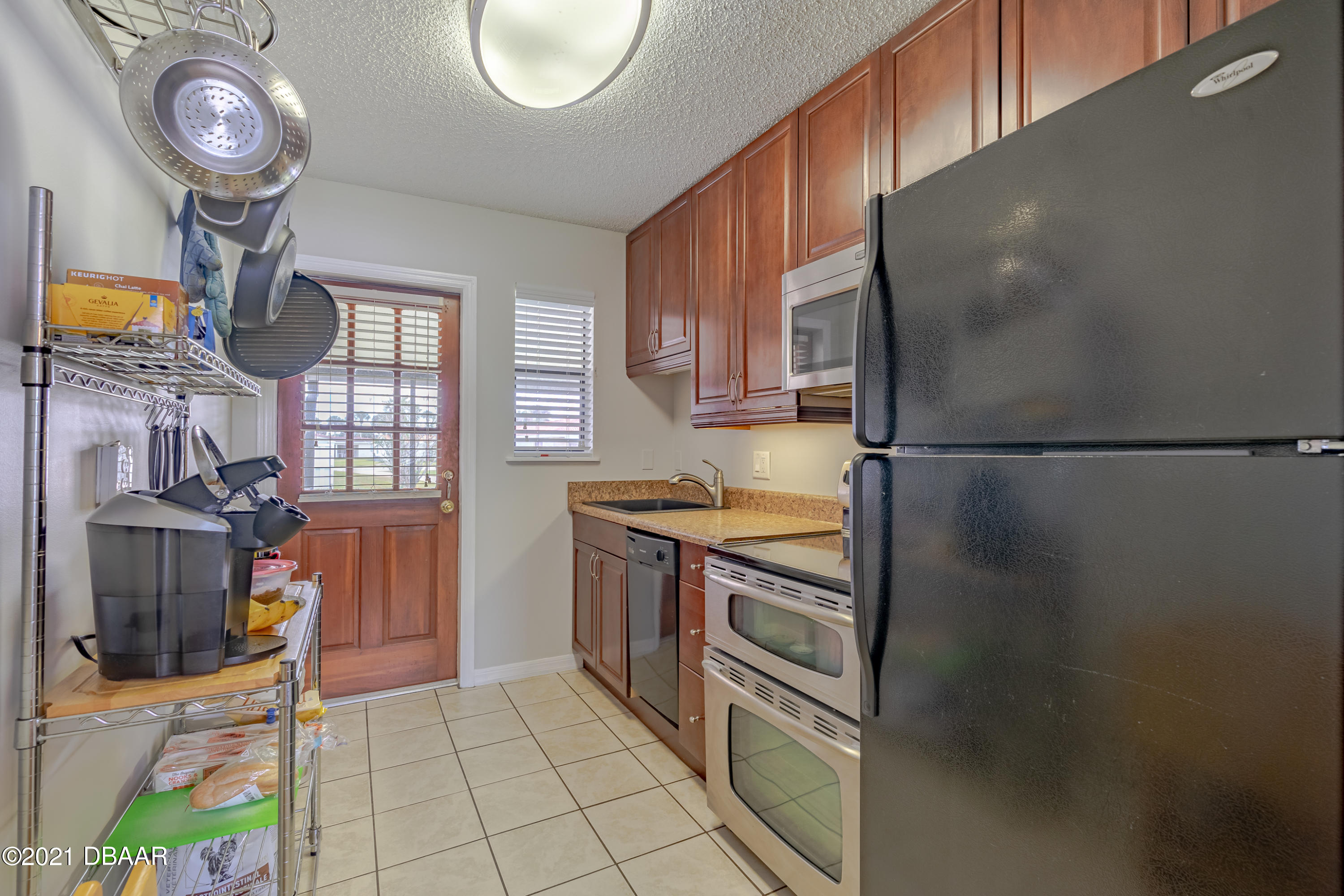 202 Northshore Drive, Unit B Ormond Beach, FL 32176 - Photo 10 of 25 a kitchen with stainless steel appliances granite countertop a refrigerator a stove and a sink