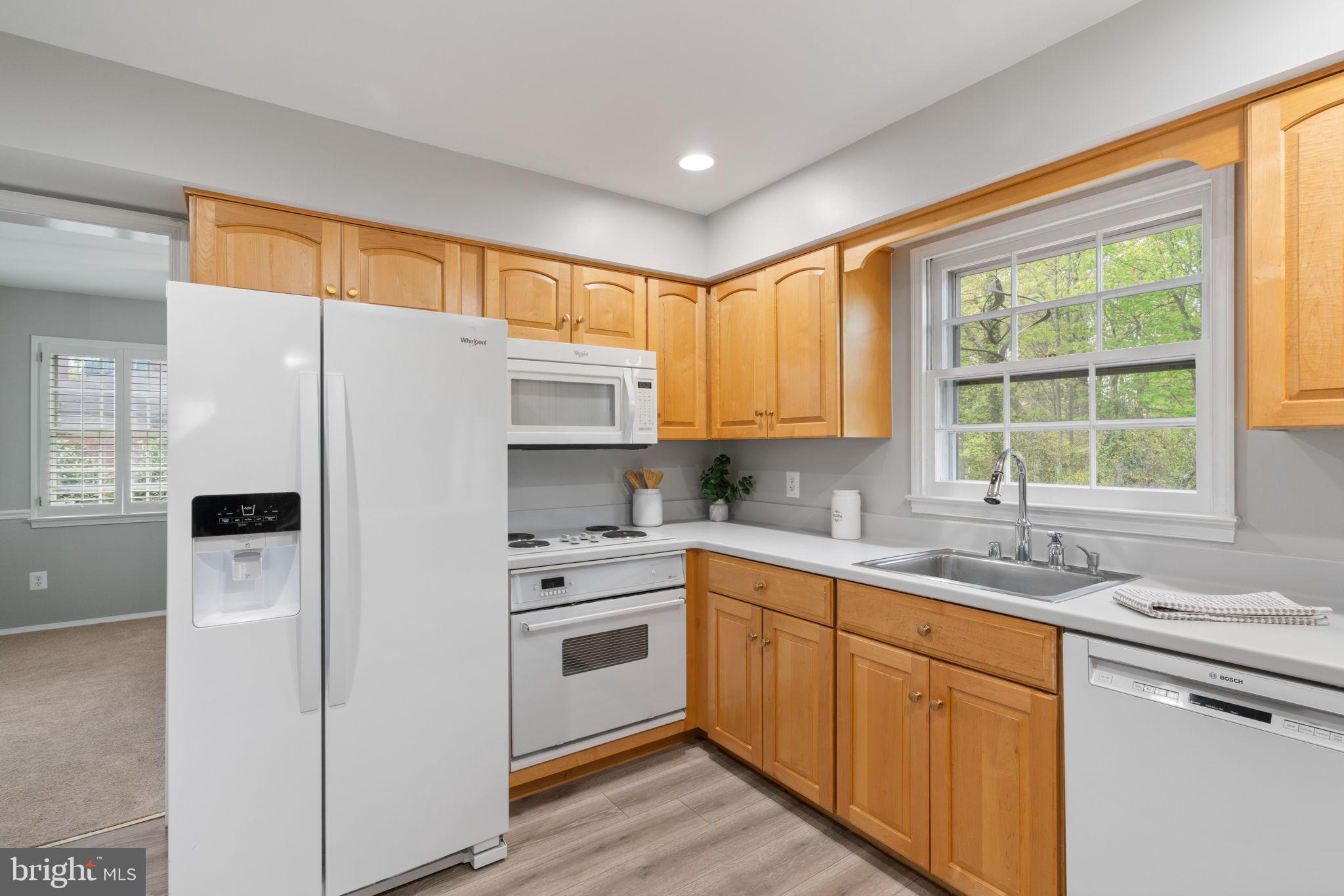 8328 Carrleigh Parkway Springfield, VA 22152 - Photo 14 of 58 a kitchen with a sink a refrigerator a window and cabinets