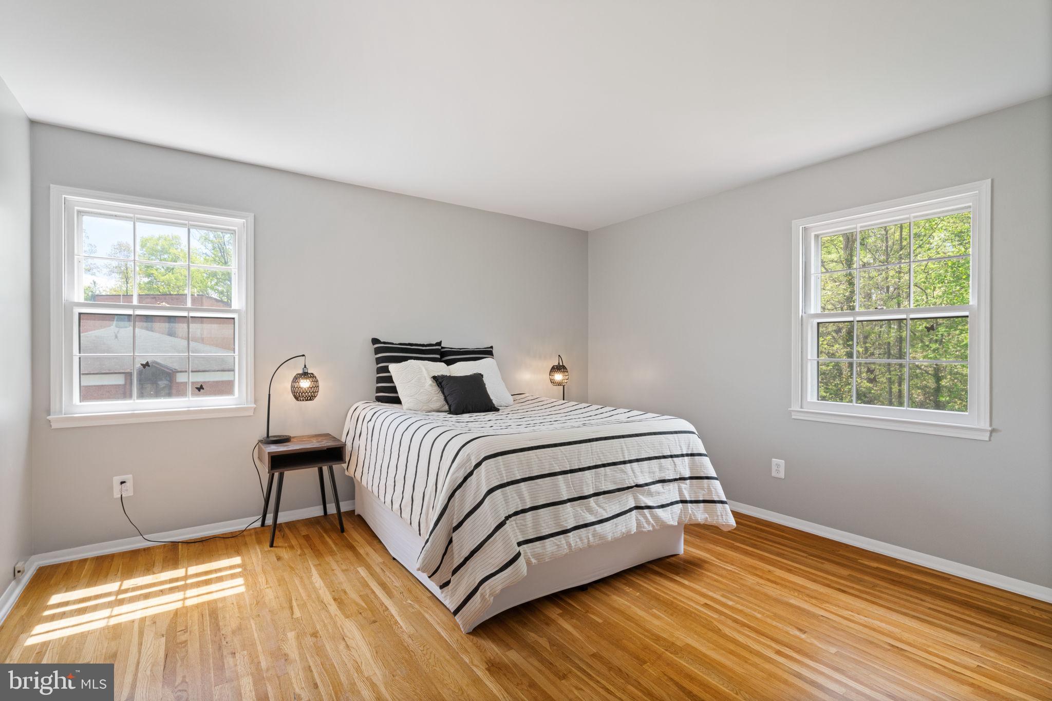 8328 Carrleigh Parkway Springfield, VA 22152 - Photo 28 of 58 a bedroom with a bed and wooden floor