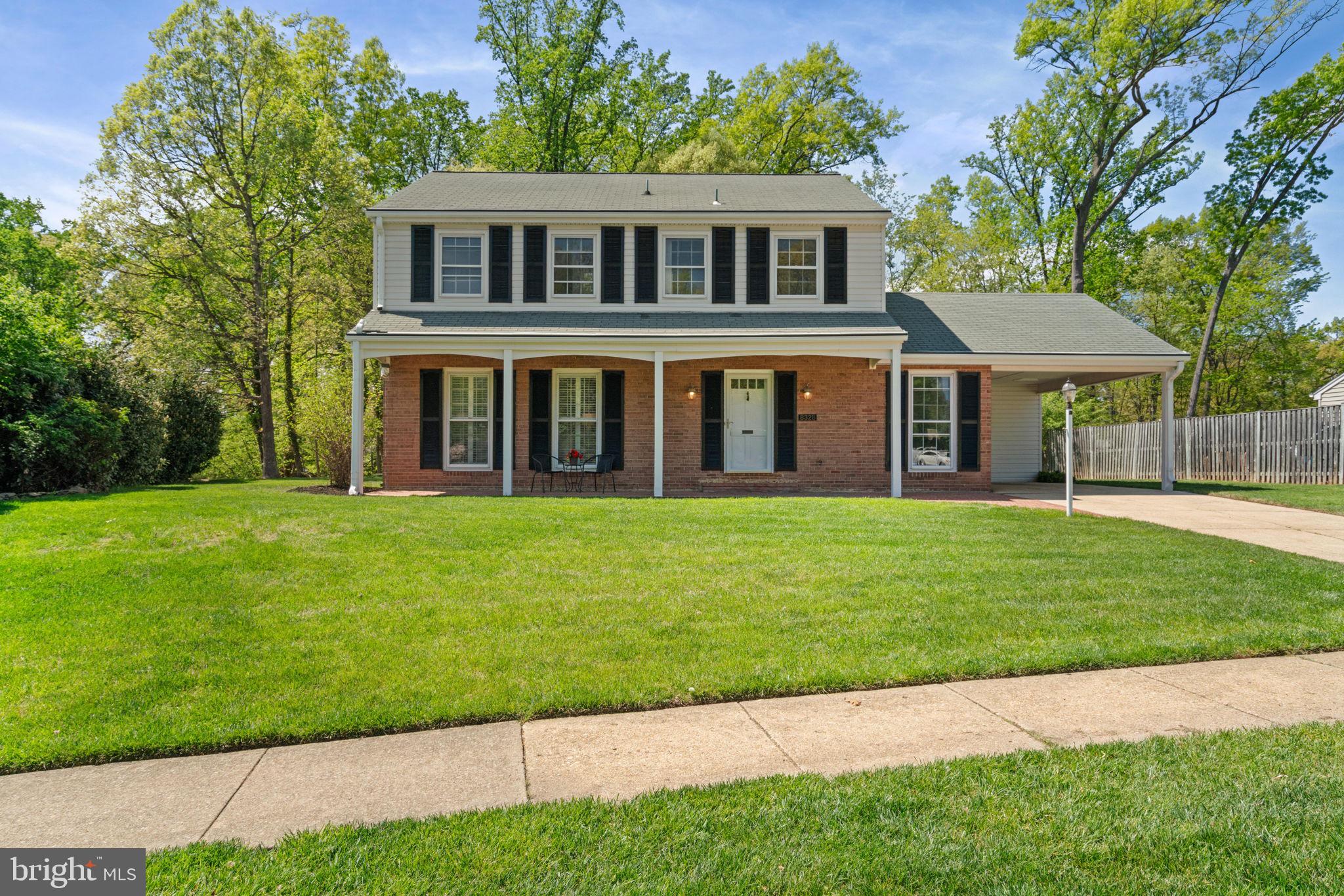 8328 Carrleigh Parkway Springfield, VA 22152 - Photo 3 of 58 a front view of a house with a garden and yard