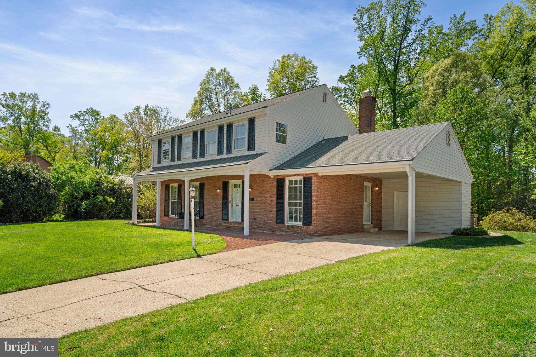 8328 Carrleigh Parkway Springfield, VA 22152 - Photo 4 of 58 a front view of a house with a garden and yard