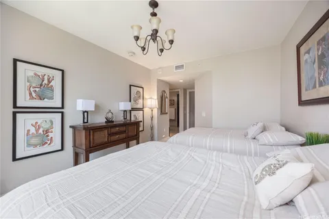 a bedroom with a large bed and a chandelier
