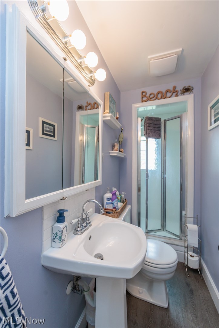 5364 Summit Road Lyndhurst, OH 44124 - Photo 6 of 42 Bathroom featuring a pedestal sink, white subway tile backsplash, mirrored medicine cabinet with vanity lighting, and a walk-in shower with clear glass enclosure