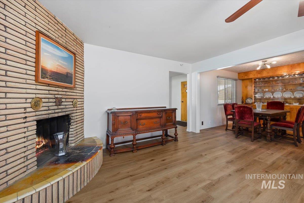 2012 21st Street Heyburn, ID 83336 - Photo 12 of 38 Dining area featuring wood finished floors, a ceiling fan, a brick fireplace, and built in features