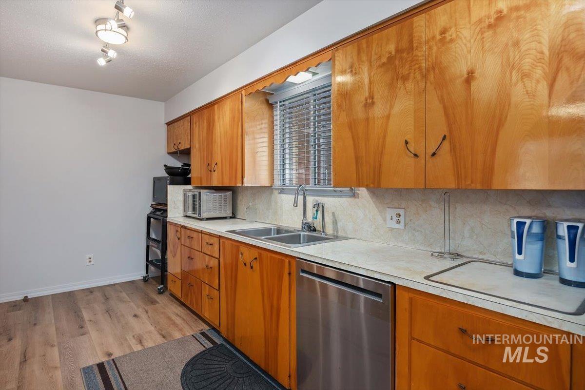 2012 21st Street Heyburn, ID 83336 - Photo 16 of 38 Kitchen featuring stainless steel appliances, light countertops, backsplash, wood finish cabinetry, and a textured ceiling