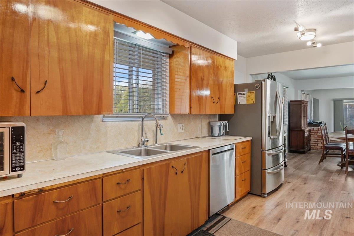 2012 21st Street Heyburn, ID 83336 - Photo 18 of 38 Kitchen with light countertops, decorative backsplash, wood finish cabinets, stainless steel appliances, and light wood-type flooring