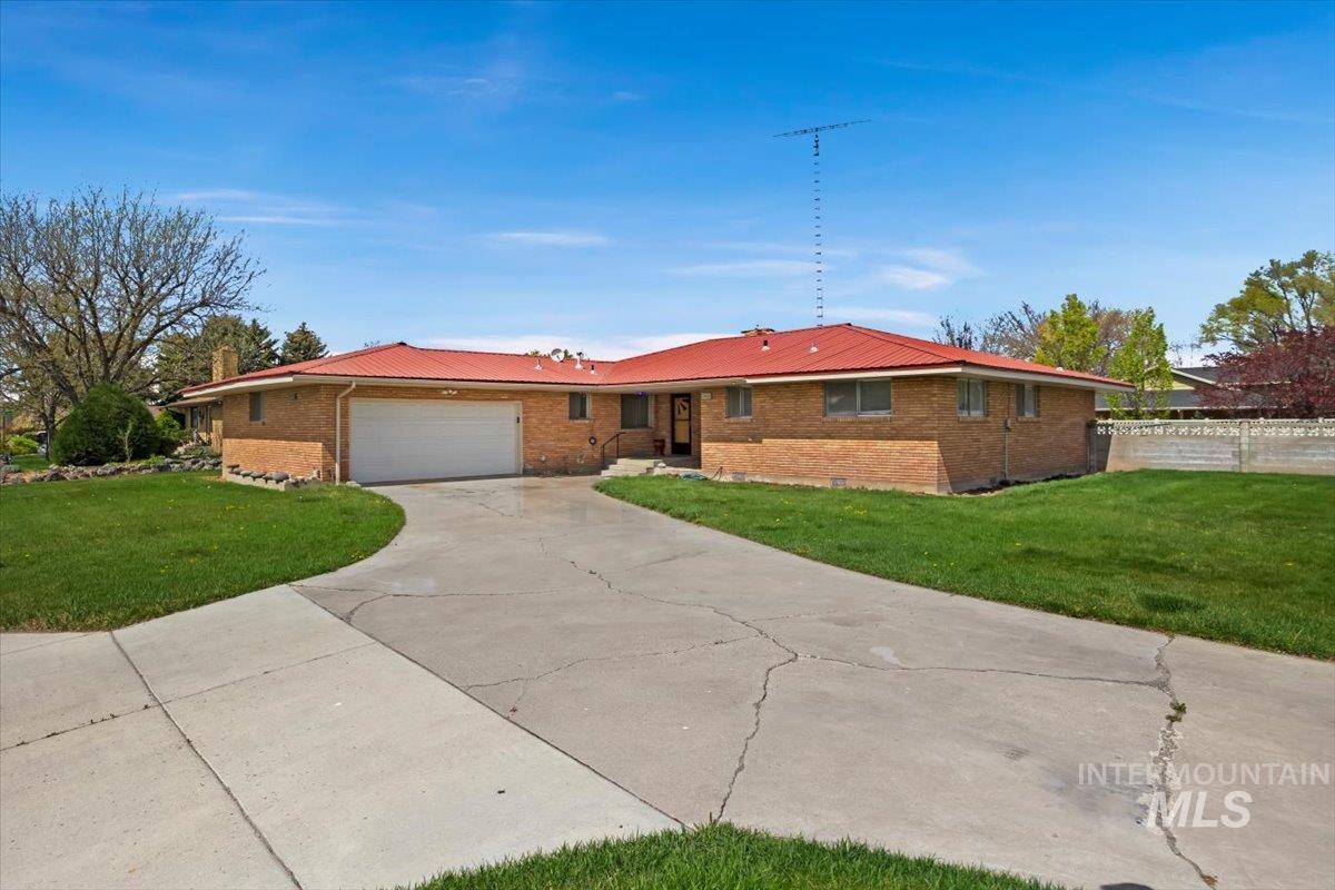 2012 21st Street Heyburn, ID 83336 - Photo 2 of 38 Ranch-style home with a front lawn, a garage, brick siding, and concrete driveway