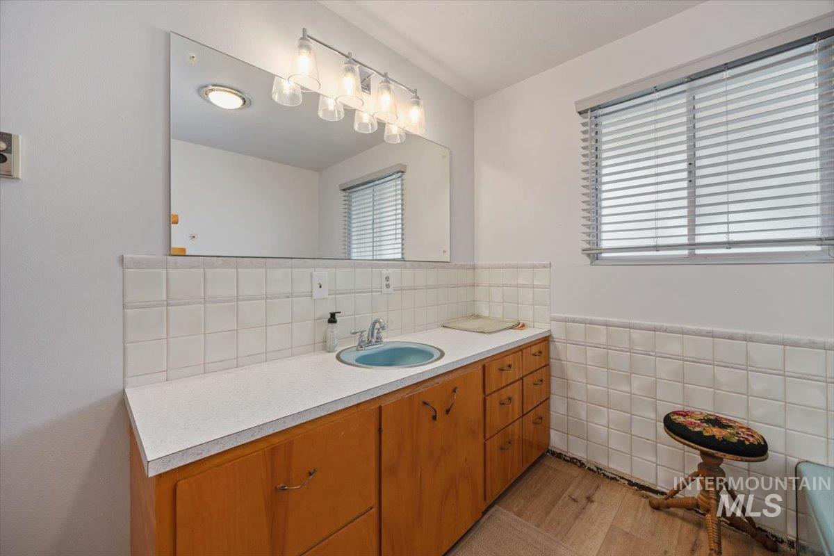 2012 21st Street Heyburn, ID 83336 - Photo 28 of 38 Bathroom featuring vanity, tile walls, and a wainscoted wall
