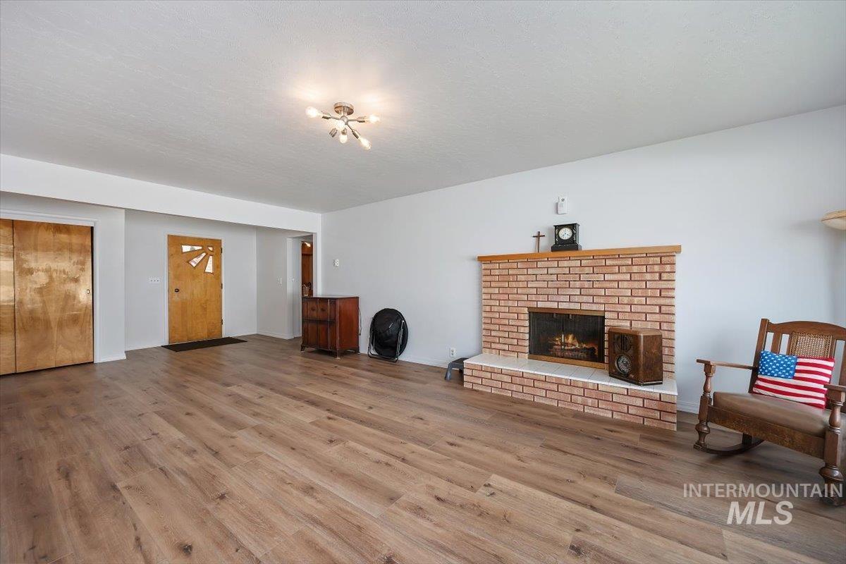 2012 21st Street Heyburn, ID 83336 - Photo 5 of 38 Living area with light wood-style floors and a brick fireplace