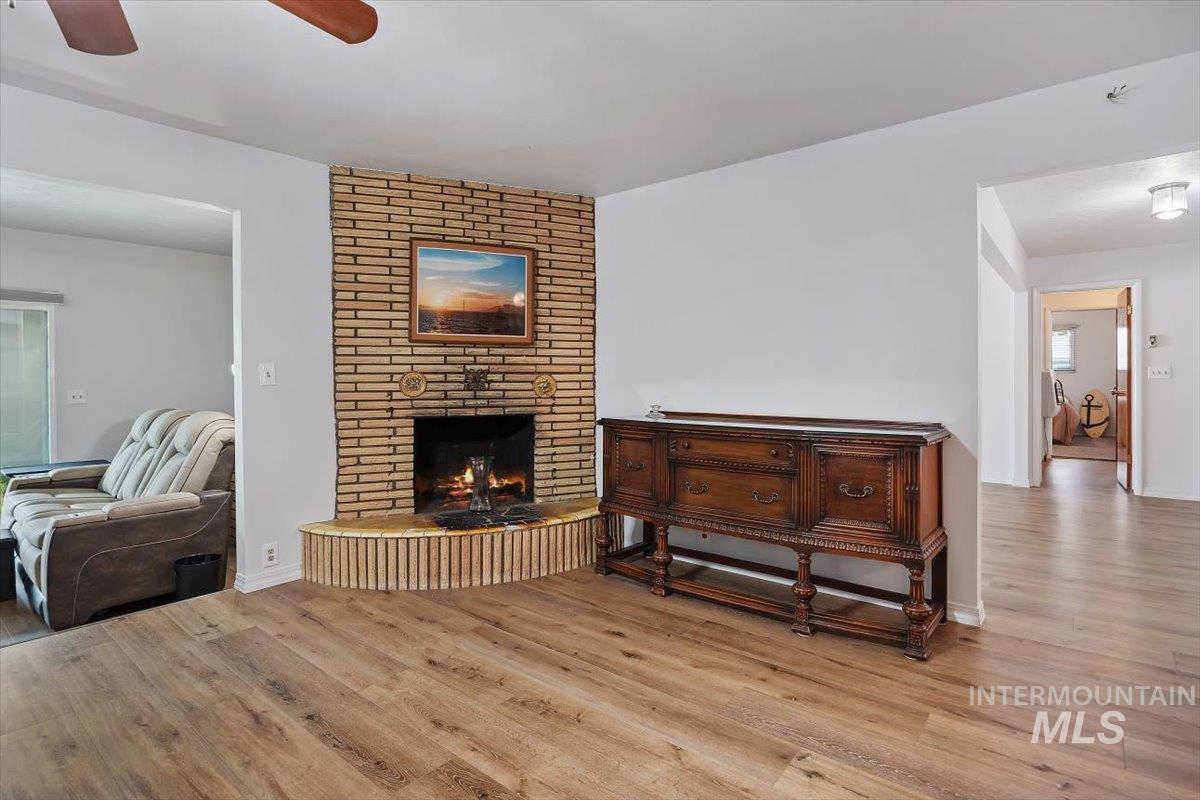 2012 21st Street Heyburn, ID 83336 - Photo 10 of 38 Living room featuring light wood-style floors, ceiling fan, and a fireplace