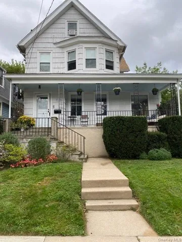 a front view of a house with a yard and potted plants