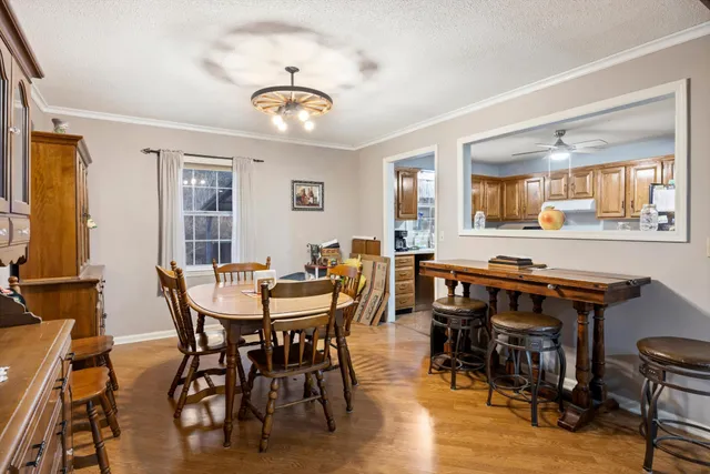 a dining room with wooden floor a glass table and chairs
