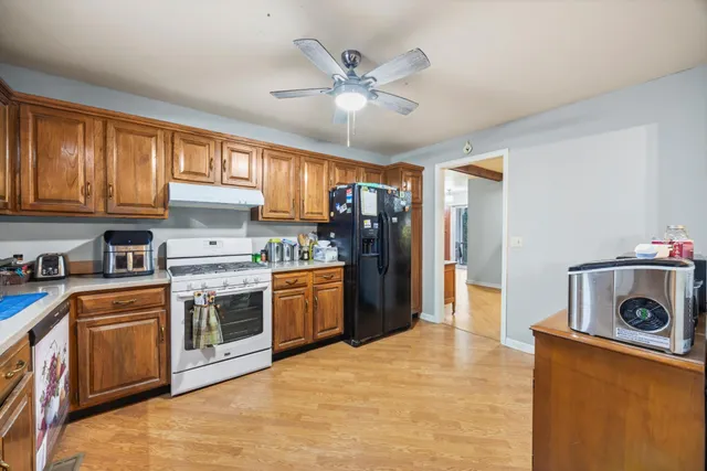 a kitchen with stainless steel appliances kitchen island granite countertop a stove a sink a refrigerator and cabinets