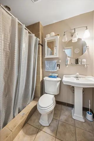 a bathroom with a sink a toilet a mirror and shower