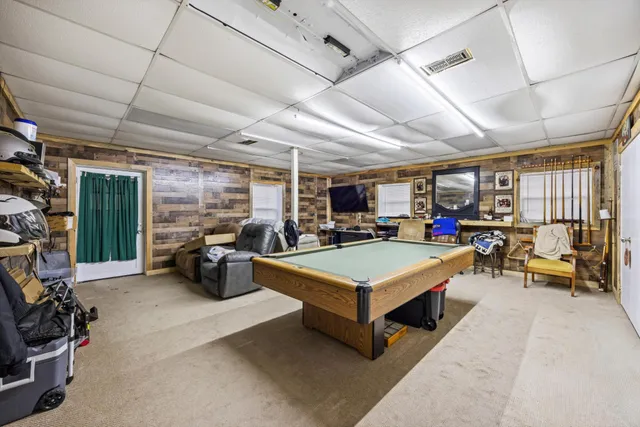 a room with pool table and windows