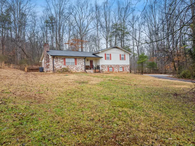 a front view of a house with a yard and trees