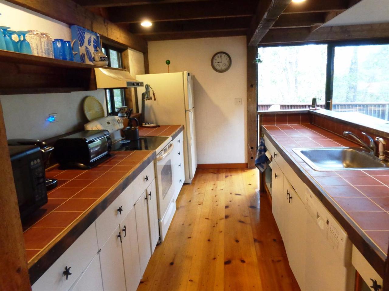 200 Gull Pond Road Wellfleet, MA 02667 - Photo 13 of 35 a kitchen with wooden cabinets a sink and a stove