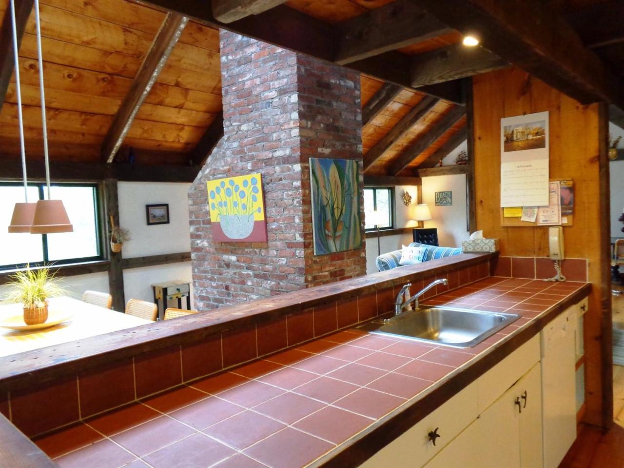 200 Gull Pond Road Wellfleet, MA 02667 - Photo 14 of 35 a kitchen with stainless steel appliances a sink and a wooden cabinets