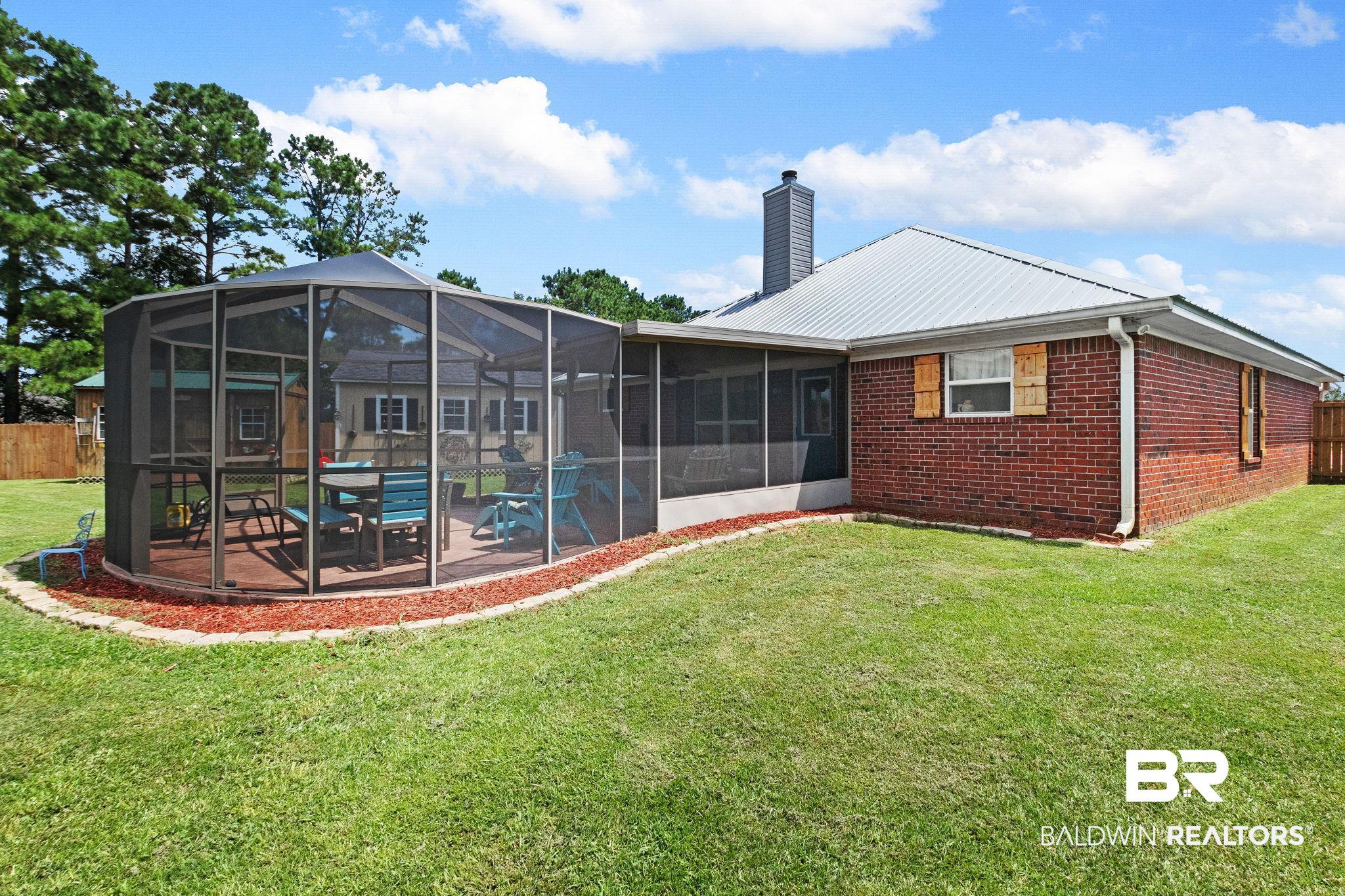 16898 Sugar Loop Foley, AL 36535 - Photo 59 of 67 Back of house with a lanai, a patio, and a lawn