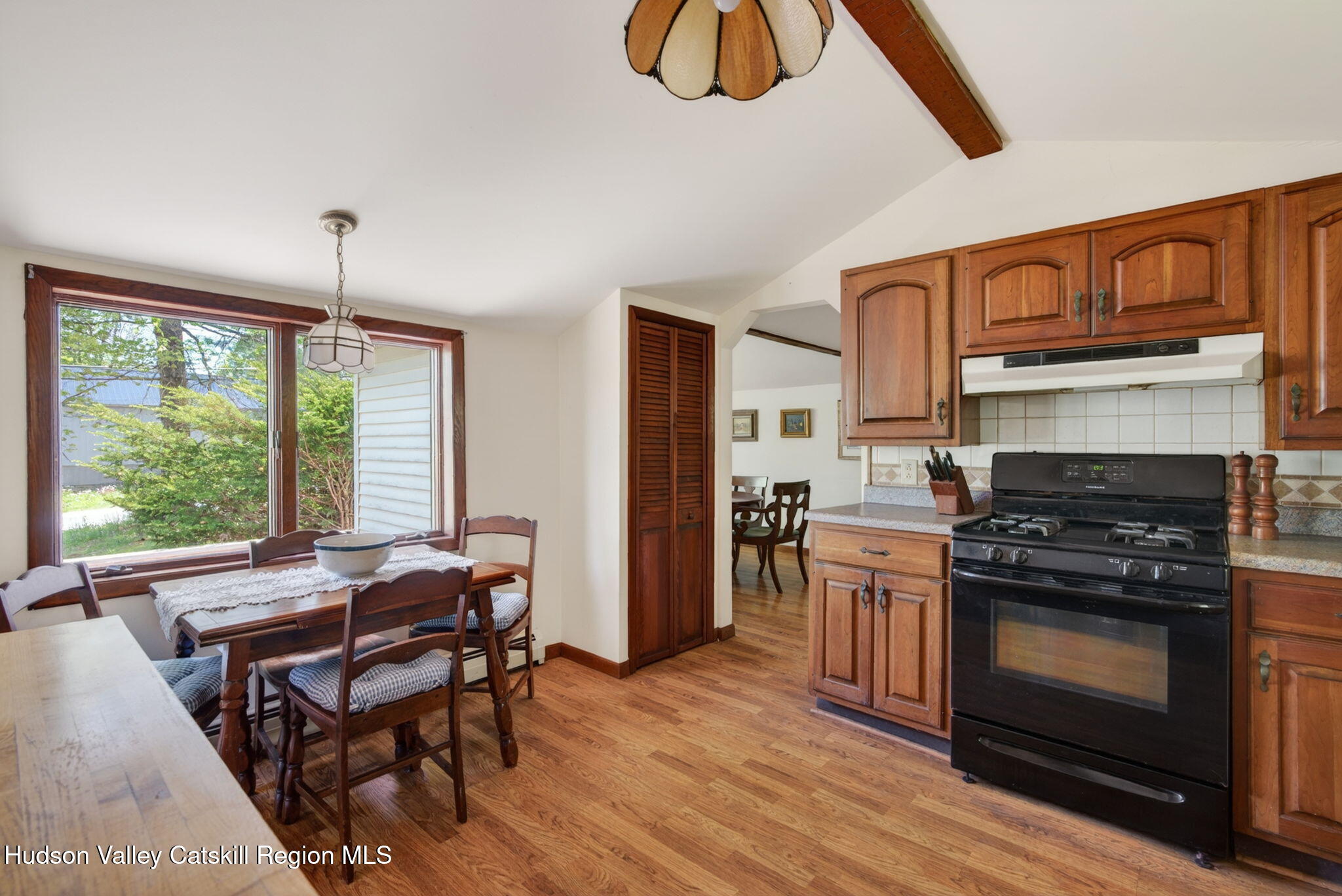 689 Old Road Windham, NY 12496 - Photo 8 of 42 a kitchen with stainless steel appliances granite countertop a stove a refrigerator a kitchen island a table and chairs with wooden floor