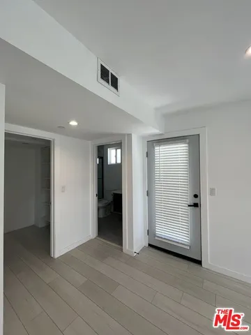 an empty room with wooden floor and closet