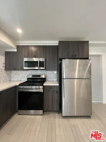 a kitchen with wooden cabinets and stainless steel appliances