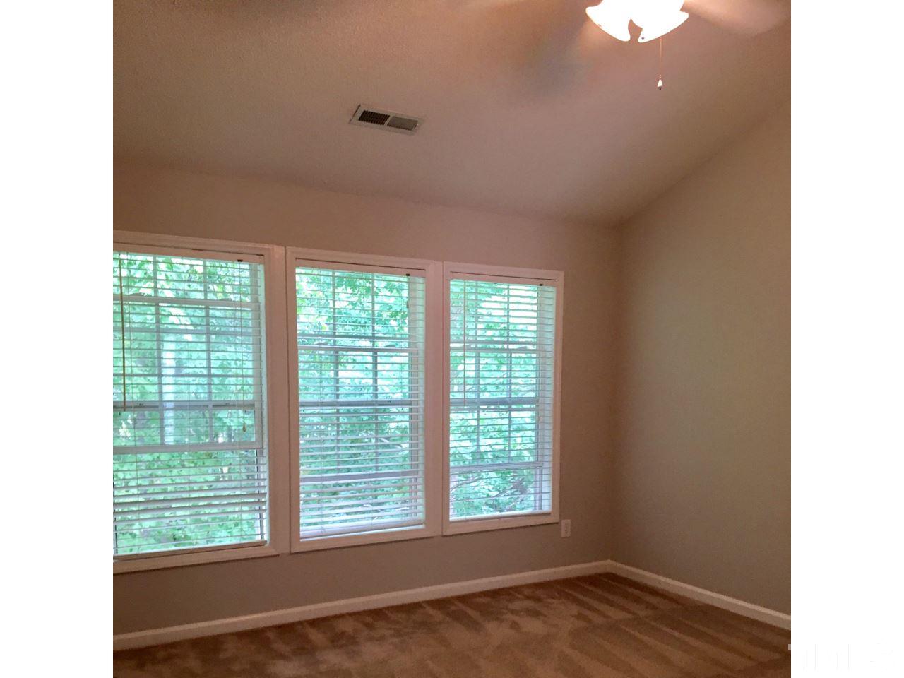 1410 Big Leaf Loop Apex, NC 27502 - Photo 12 of 20 a view of an empty room with wooden floor and a window