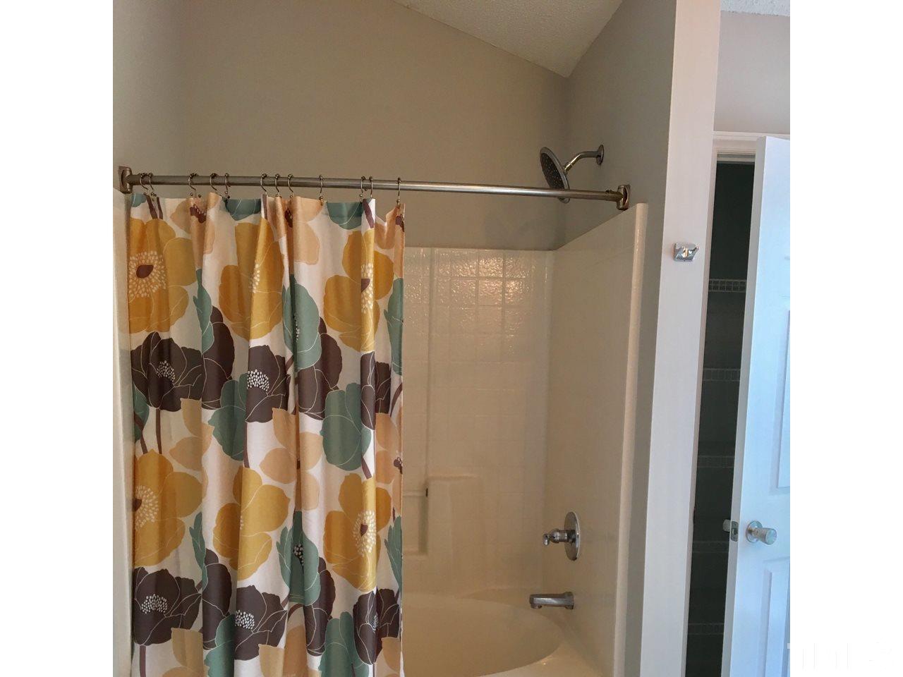 1410 Big Leaf Loop Apex, NC 27502 - Photo 14 of 20 a bathroom with a shower and a tub