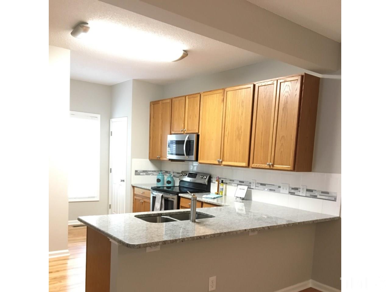 1410 Big Leaf Loop Apex, NC 27502 - Photo 5 of 20 a kitchen with stainless steel appliances granite countertop a sink and a window