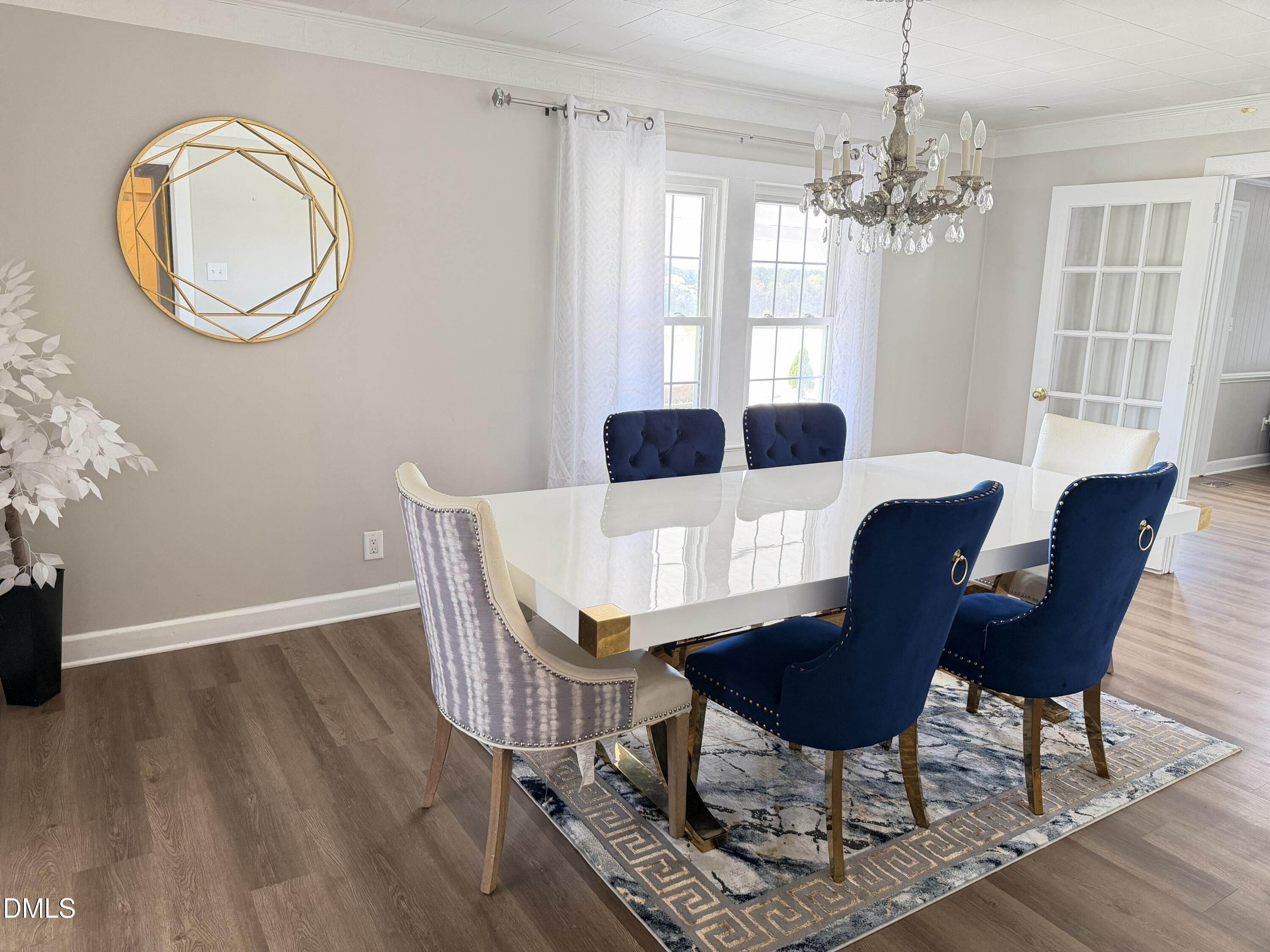 1899 Stewart Farm Road Henderson, NC 27537 - Photo 12 of 27 a dining room with furniture a chandelier and wooden floor
