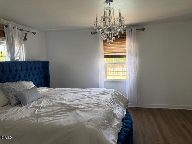 1899 Stewart Farm Road Henderson, NC 27537 - Photo 17 of 27 a bed sitting in a bedroom next to a chandelier and a window
