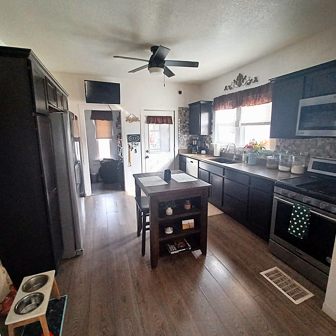 122 South Beach Street Kewanee, IL 61443 - Photo 27 of 49 a kitchen with granite countertop a refrigerator a sink a stove and chairs