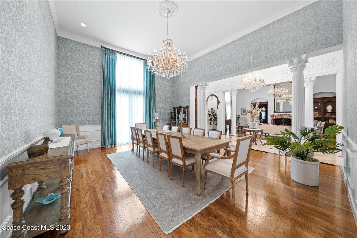 2815 Turtle Mound Road Melbourne, FL 32934 - Photo 15 of 115 a dining room with wooden floor a chandelier a wooden table and chairs