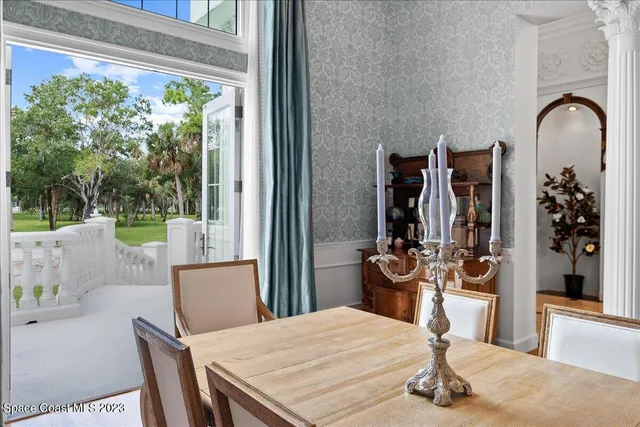 a living room with furniture chandelier and a large window