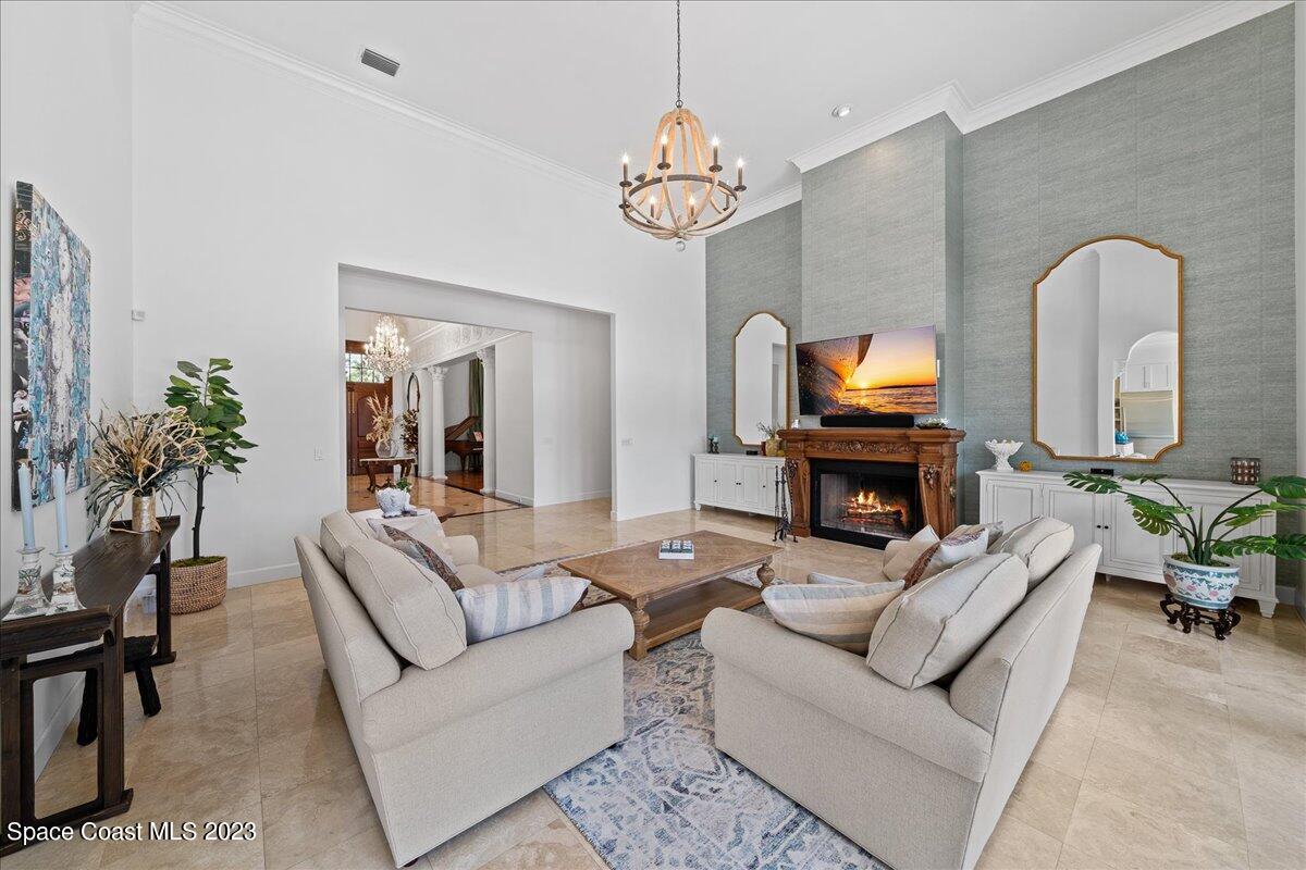 2815 Turtle Mound Road Melbourne, FL 32934 - Photo 26 of 115 a living room with furniture a fireplace and a chandelier