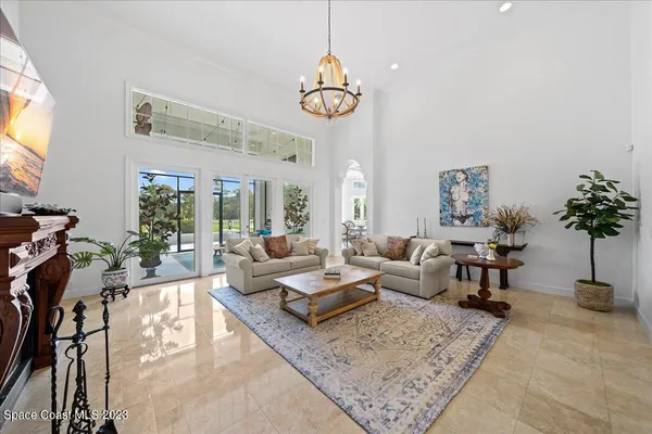 a living room with patio furniture and a chandelier