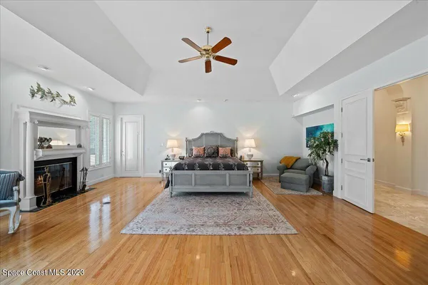 a view of a house with a big yard and palm trees