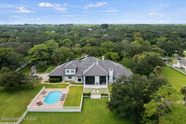 a dining room with wooden floor a chandelier a wooden table and chairs