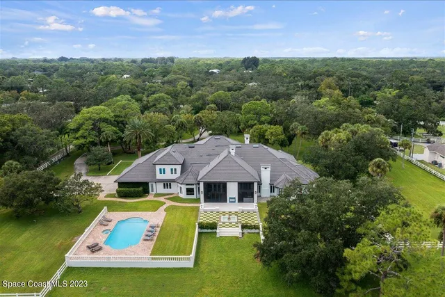a dining room with wooden floor a chandelier a wooden table and chairs